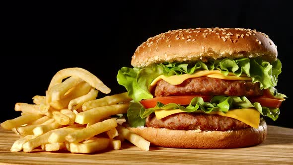 Craft Beef Burger and French Fries, Sauce Isolated on Black Background. Fast Food