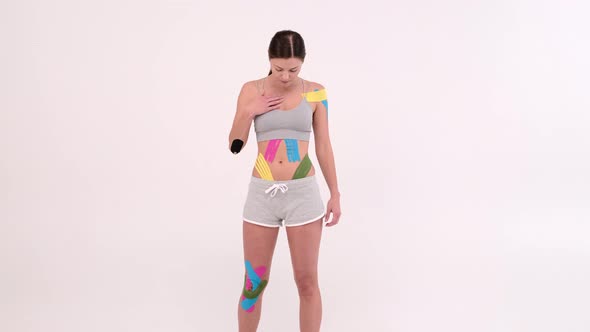 Young fit women showing on her body applied elastic kinetic tape, Kinesiology physical therapy