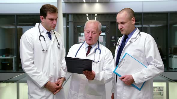 Team of doctors discussing over clipboard