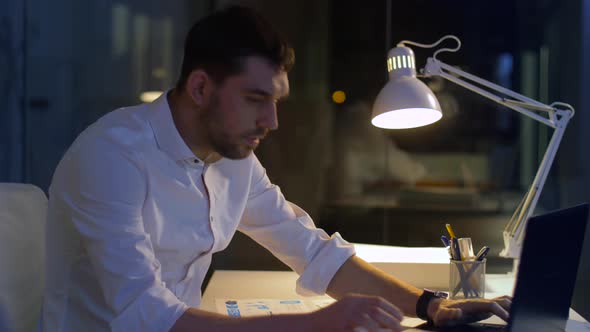 Businessman with Files and Laptop Working at Night 13