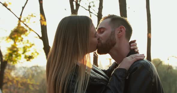 Romantic Couple Kissing and Having Joy on a Walk at Autumn Park with Sun