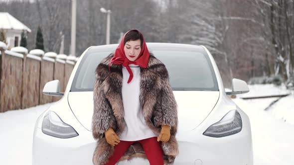 Stylish Woman in Fur Coat and Head Scarf in Winter Backyard