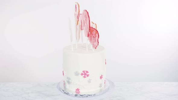 Tall Round Cake with Italian Buttercream Frosting Decorated with Fondant Snowflakes and Topped with