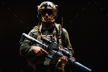 Special forces soldier with rifle on black background