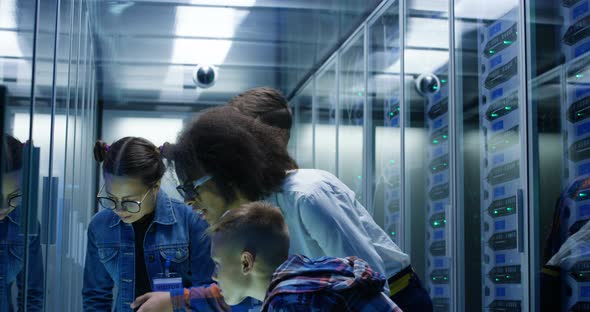 Female Technician Showing Around Children in a Server Park