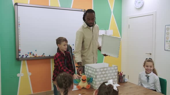 An African American Teacher Teaches a Group of Children English By Playing with Them