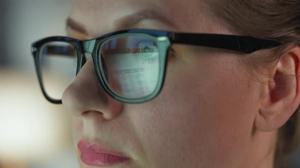 Woman in Glasses Looking on the Monitor and and Working with Charts and Analytics