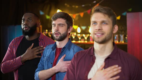 Patriotic Football Fans Listening to Anthem and Hugging, Watching Game in Bar