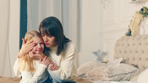 Mom Soothes a Crying Little Girl