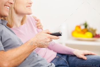 cheerful mature couple sitting together and watching TV