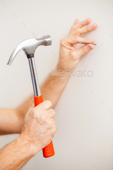 Hammering a nail. Close-up of man hammering a nail