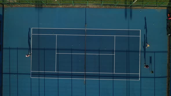 Top View of a Blue Tennis Court with Players in training, City Tennis Court on the Street 