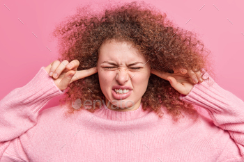 oud noise cannot stand annoying sound cannot focus in noisy crowded place wears casual jumper feels discomfort isolated over pink background