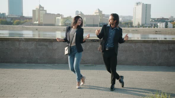 Dance Loop of Happy Couple Man and Woman Dancing Outdoors Smiling Against River Embankment