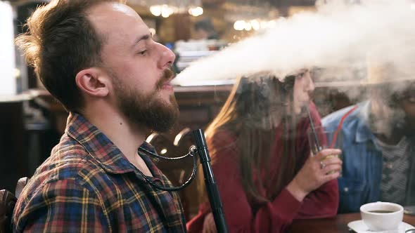 Caucasian Young Man Smoking Hookah in the Bar