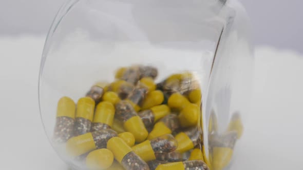 Shot of yellow and brown granule capsule in a glass bottle