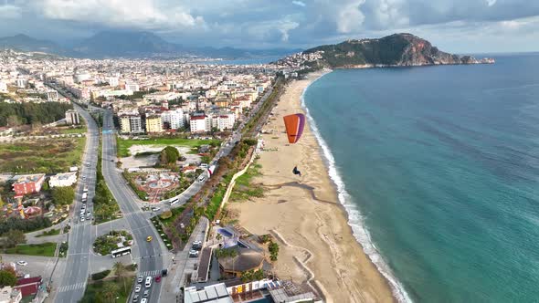 Aerial drone view of parachute jumper flying over beautiful Alanya