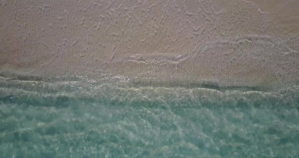 Beautiful fly over travel shot of a white sandy paradise beach and blue water background