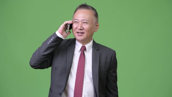 Mature Japanese Businessman Using Phone