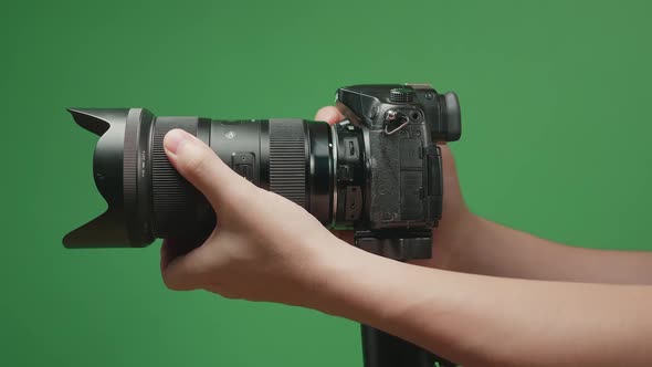 Hand Adjusting Zoom And Focus On Digital Camera Lens On Green Screen Chroma Key. Photography Concept