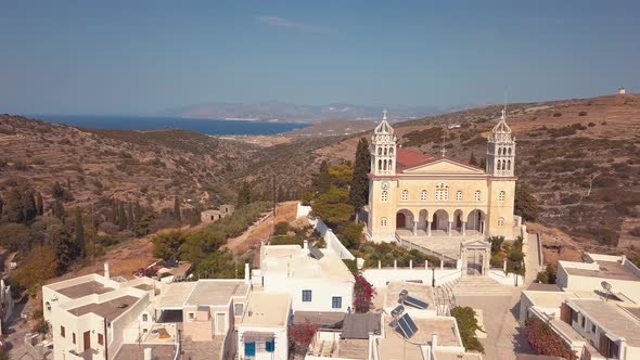 Aerial Drone Shot Punching through the Village into the Rolling Hills of the Island of Lefkes Greece