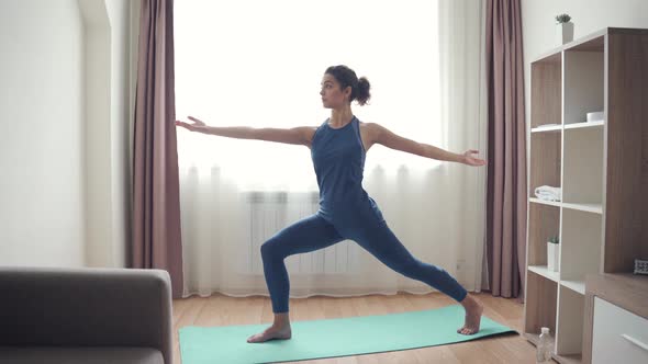 Young Sporty Slim Fit Woman Doing Hatha Yoga at Home at Quarantine