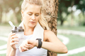 What time is it? Woman relaxing after workout outdoors. Copy space on the right side - PhotoDune Item for Sale