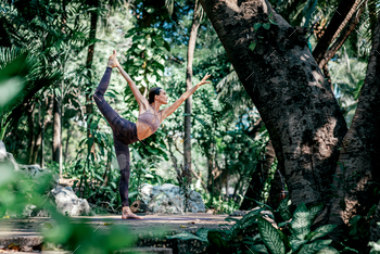 ncer’s pose, Natarajasana while practicing yoga outdoors, in a garden. Healthy lifestyle and relaxation concept