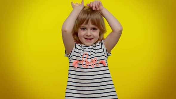 Lovely Funny Teen Kid Child Girl Smiling Friendly and Doing Bunny Ears Gesture on Head Having Fun