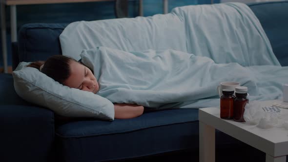 Person with Sickness Laying on Couch with Blanket