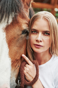 Close up portrait. Happy woman with her horse on the ranch at daytime / Photodune
