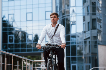 Professional politician. Businessman in formal clothes with black bicycle is in the city / Photodune