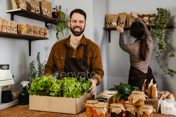 White sellers man and woman smiling while working in local eco shop / Photodune