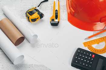 safety helmet and Scrolls of engineering drawings and supplies / Photodune