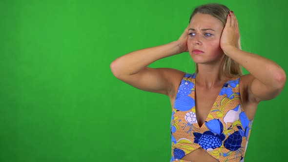Young Pretty Blond Woman Is Afraid (Woman Covers His Ears with Hands) - Green Screen - Studio