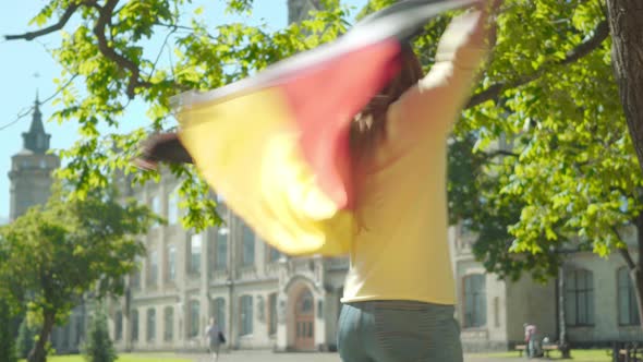 Beautiful Redhead Woman in Eyeglasses Spreading Hands and Spinning with German Flag. Portrait of