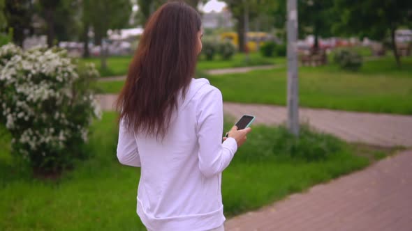 Back View Brunette Holding Smartphone Chatting Online