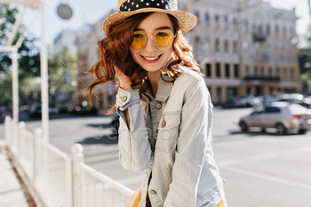 Fascinating ginger young woman in casual outfit posing on the street. Outdoor shot of joyful girl w / Photodune