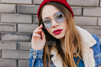 Close-up portrait of adorable girl with bright makeup looking to camera with serious face expressio / Photodune