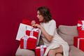 Short-haired curious woman opening presents. Indoor photo of winsome surprised female model posing - PhotoDune Item for Sale