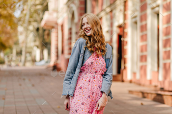cheerful happy blonde girl smiling and looking to the left on the background of a building / Photodune