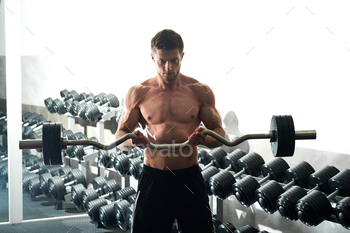 Young fitness man with muscular body exercising with ez curl bar / Photodune