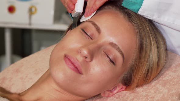 Happy Woman Smiling To the Camera While Getting Ultrasonic Facial Treatment