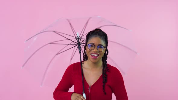 Nice Young African American Girl Having Fun with Transparent Umbrella in Photo Studio