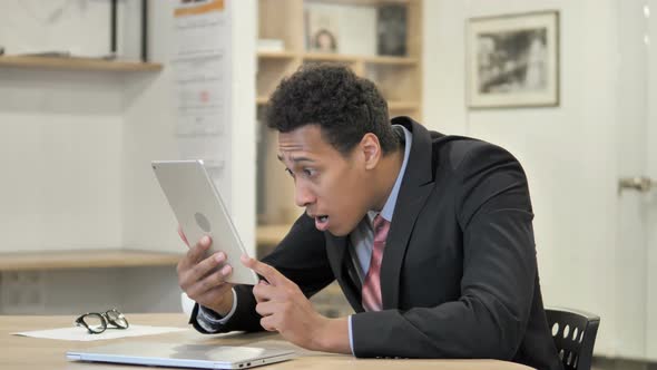 Shocked African Businessman Using Tablet