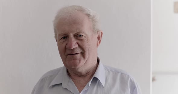 Portrait of Handsome Senior Man Laughing Into Camera on Background