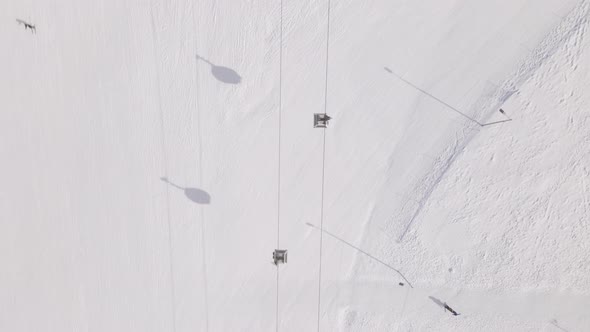 Flying over rope-way with gondolas at mountain resort Crystal Park in Bakuriani. Snowy winter day.