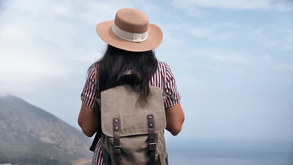 Back View Elegant Travel Woman in Straw Hat and Backpack Admiring Amazing Sea Scenery Mountain Peak