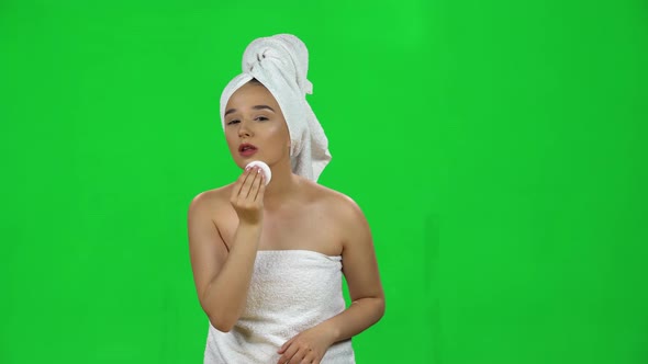 Woman in White Towel on Her Head Using Cotton Pad, Cleans Her Face Isolated on Green Screen