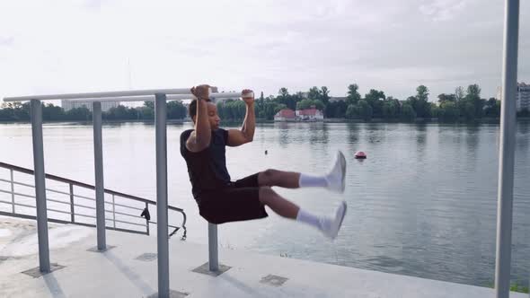 Muscular Man Doing Abdominal Exercises Near the Lake